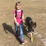 A young girl named Cami is walking her friend, a German Shepherd dog named Linux.